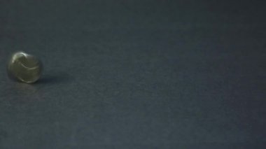 Metal yazı tura dönüşü. Madeni para iplik siyah bir arka plan üzerinde döner.