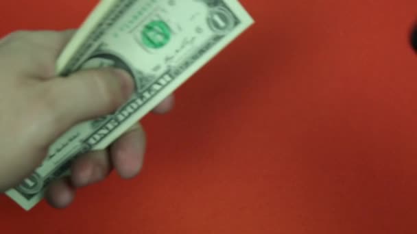 紙のお金のドルとホッチキス オレンジ色の背景にホッチキスで紙幣の束に穴を開けます — ストック動画