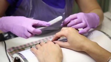 Sevimli kız ana Manikür yapıyor. Güzellik salonunda esmer kız ellerinde tırnak cilası manikür verilir.