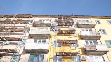 İşçiler ve sıcak cephe bina onarım. Eski ev mineral yün ile sıkıştırılır ve binanın dış kaplı. Sigortası olmayan yükseklikte çalışma