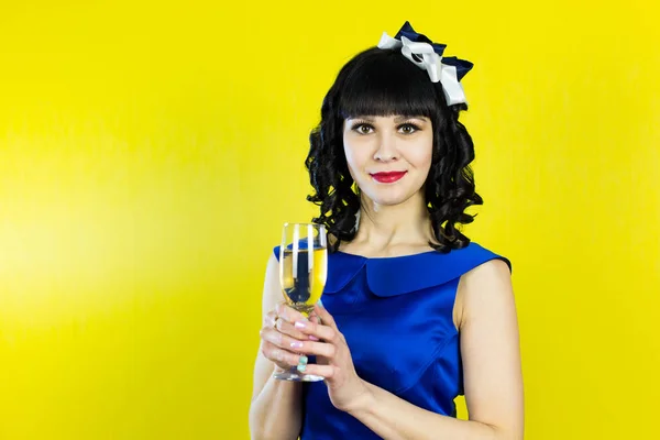 Uma garota com uma taça de champanhe sorri na frente da câmera . — Fotografia de Stock