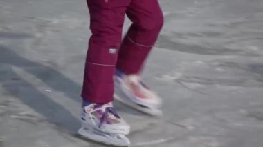 Küçük kız gülüyor ve buz üzerinde kaymaktadır. Bir buz pateni pisti kış elbiseleri yalnız bir kız rides.