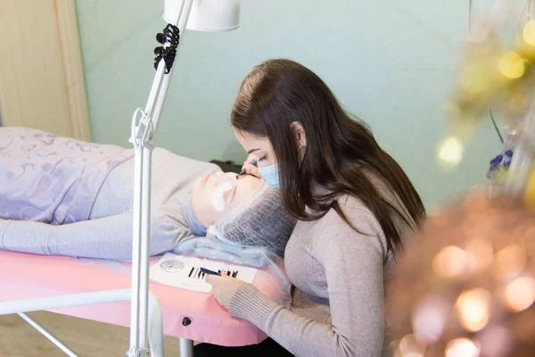 Het maken van de opbouw van nieuwe wimpers voor het meisje. — Stockfoto