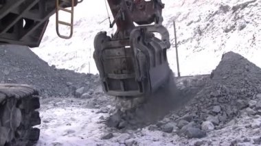 Ekskavatör taş ocağında bir demet kesintiler. Kaya, tam bir büyük Ekskavatör kova.