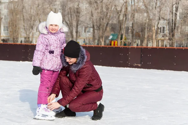 Mamá aprende a una hija a patinar . — Foto de Stock
