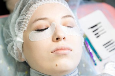 Genç bir kız bir güzellik salonu kirpik artırır.