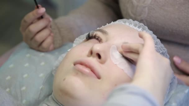 一个年轻女孩在美容院增加睫毛 增加和容积睫毛延长到一个金发女郎的过程 — 图库视频影像
