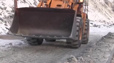 Bir traktör bir kova ile kariyer edinmek gidiyor. Forklift kova kamera, yakın çekim yaklaşıyor.