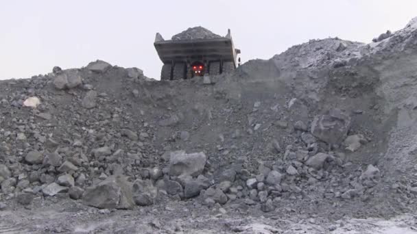 Un grand camion à benne verse 50 tonnes de minerai dans la falaise. Du corps de la voiture dans une carrière pierres verser .