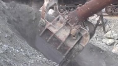 Ekskavatör taşları arabalara yükler. Taş ocağı demiryolu otomobillerde içine cevheri yükleme.