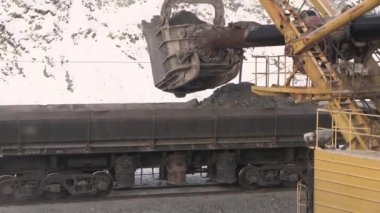 Ekskavatör taşları arabalara yükler. Taş ocağı demiryolu otomobillerde içine cevheri yükleme.
