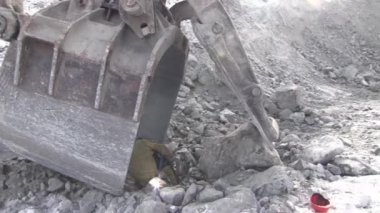 Bir çalışma metal kaynakçı bir taş ocağında çalışıyor. Kaynak maskesi ve bir elektrot yardımıyla tulum işçi Ekskavatör Kepçe onarır.