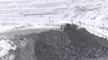 Buldozer alanında kariyer kışın çalışır. Bir taş ocağı minerallerin iş yerinde bir kepçe ile traktör.