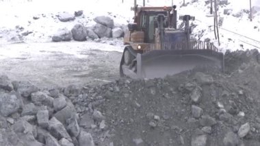 Buldozer alanında kariyer kışın çalışır. Bir taş ocağı minerallerin iş yerinde bir kepçe ile traktör.