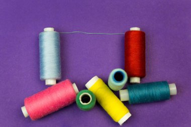 Mavi bir arka plan iş parçacığı ile birkaç makaraları.