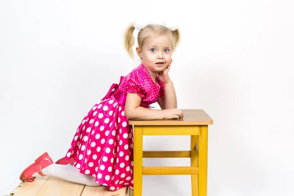 Niña de 3 años con un vestido rojo con lazos en el pelo . —  Fotos de Stock