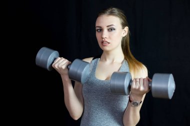 Atlet siyah bir arka plan ağır dumbbells ile nişanlandı.