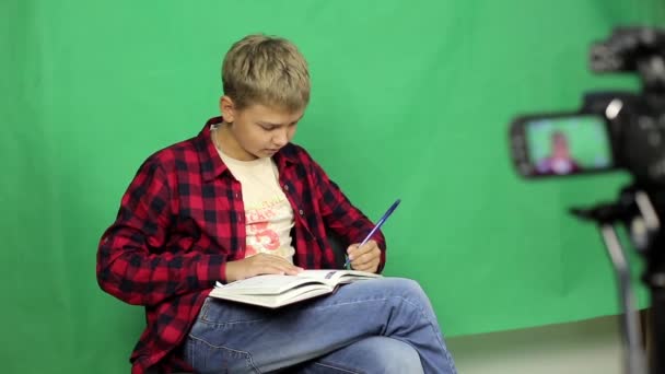 男孩视频博主为剧情写剧本 青少年正在为下一期新闻频道的课文工作 — 图库视频影像