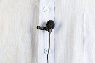 Bir adamın gömleği üzerinde küçük ilik mikrofon.