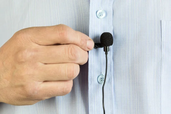 Um pequeno microfone de botão na camisa de um homem . — Fotografia de Stock