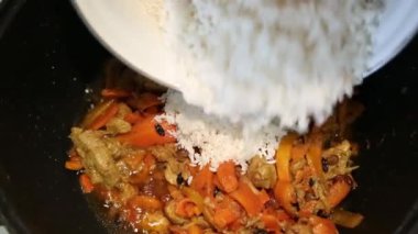 Hazırlık pirinç yemekleri - Margilan Özbekistan pilav. Tavada kızarmış et ve baharatlar ile pirinç dökün.