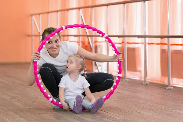 Mamá y su hija se dedican a los deportes con un aro . — Foto de Stock