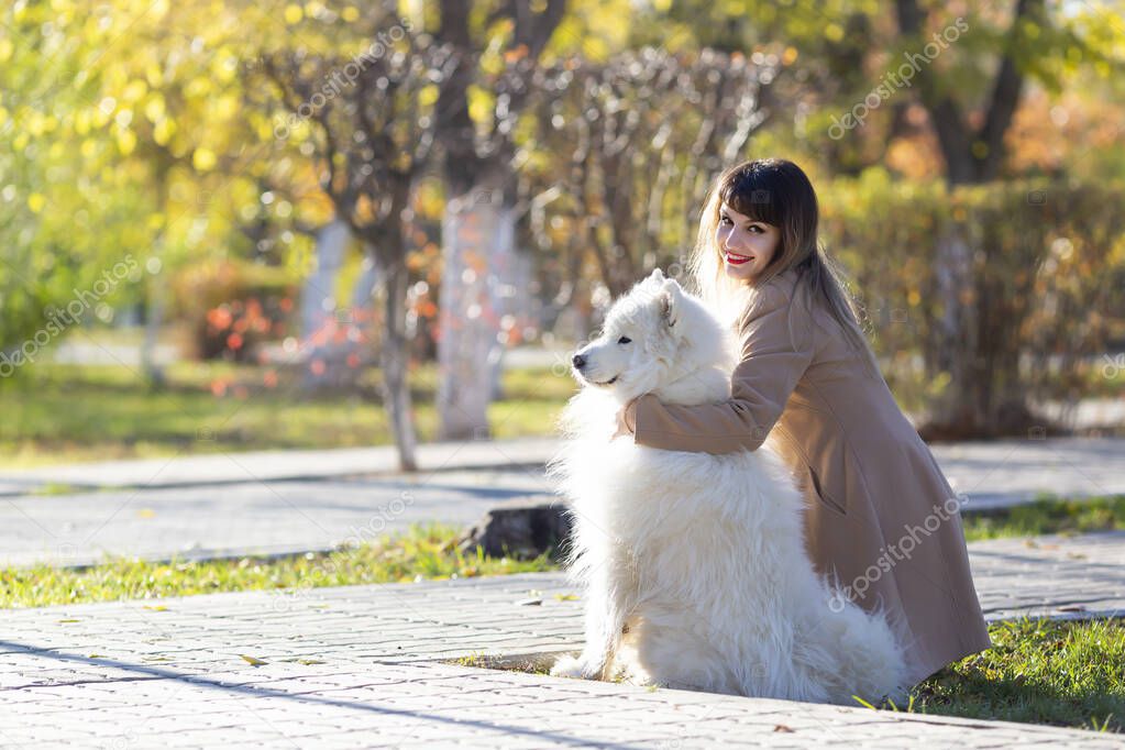 The mistress with her dog is dreamily looking into the distance,