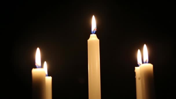 Flamme de bougie sur un fond sombre. Plusieurs bougies brûlent dans un chandelier lors d'un événement religieux .