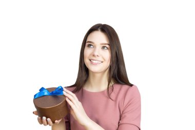 Güzel esmer kız geniş bir gülümsemeyle elinde bir hediye tutuyor..