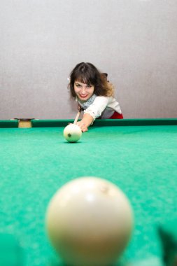 Esmer kız bilardo oynuyor. Hafta sonu akşamı 30-35 yaşlarında genç bir kadın bilardo topunu bilardo topunda yendi.