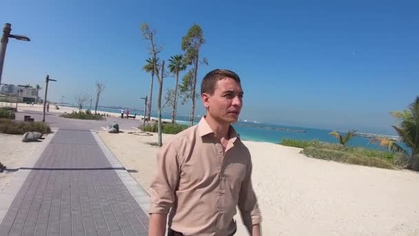 Een Volwassen Man Loopt Langs Stoep Langs Het Strand Een — Stockvideo