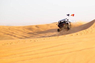 Spor, çölün kum tepelerinde toplanır. Çöl Rallisi Spor Yarışı. Kum bulutu