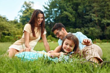 Mutlu genç aile parkı. Ebeveynler ve çocuklar oynarken eğleniyor