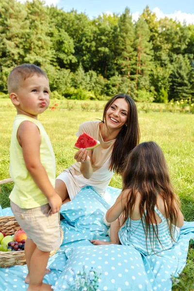 Η μητέρα με τα παιδιά διασκεδάζουν στο πάρκο. Ευτυχισμένη οικογένεια σε εξωτερικούς χώρους — Φωτογραφία Αρχείου