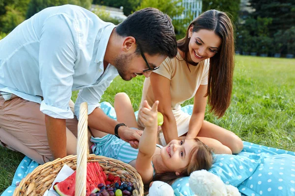 Família em Park. Jovens pais felizes e criança relaxante ao ar livre — Fotografia de Stock