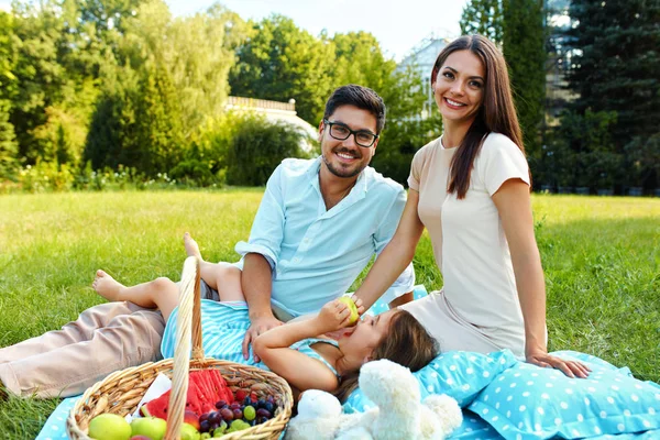 Rodziny w parku. Szczęśliwych młodych rodziców i dziecka, relaks na świeżym powietrzu — Zdjęcie stockowe