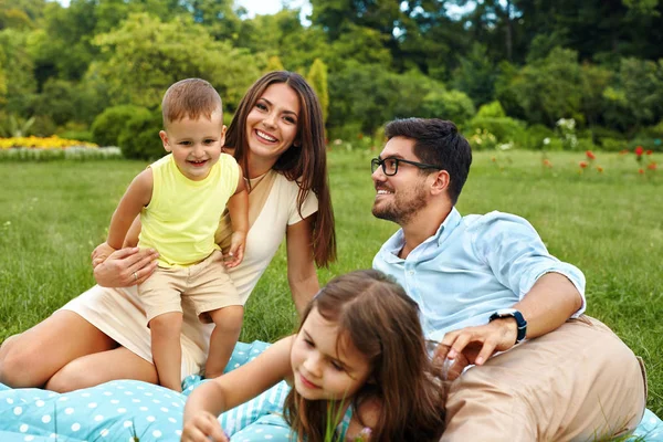 Glückliche junge Familie im Park. Eltern und Kinder haben Spaß, spielen — Stockfoto