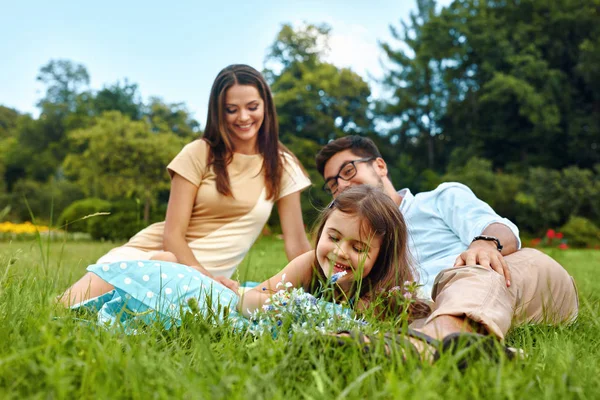 幸福的年轻家庭在公园里。父母和孩子们玩，玩 — 图库照片