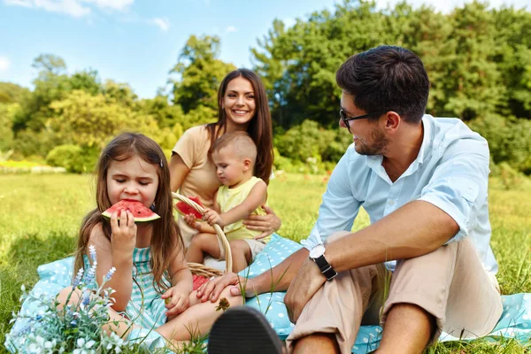 Familia en el picnic. Feliz familia joven divirtiéndose en la naturaleza — Foto de Stock