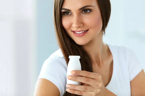 Nutrición dietética. Hermosa mujer sonriente bebiendo yogur en interiores — Foto de Stock