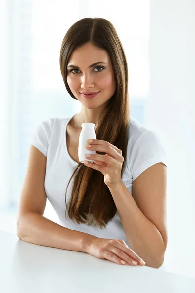 Nutrição dietética. Mulher sorridente bonita bebendo iogurte dentro de casa — Fotografia de Stock