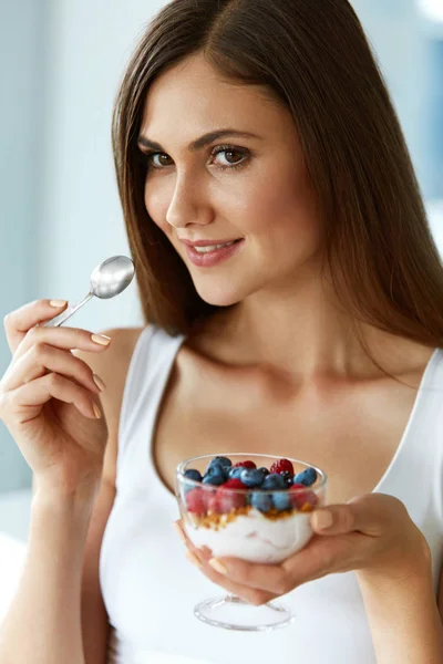 Vacker kvinna äta yoghurt, bär och spannmål. Hälsosam kost — Stockfoto