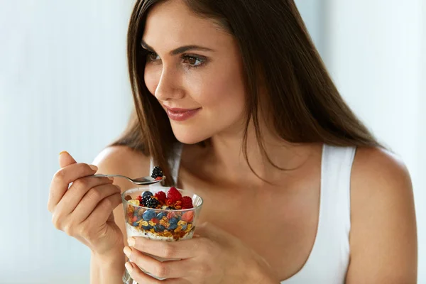Gyönyörű nő evés joghurt, bogyók, gabona. Egészséges táplálkozás — Stock Fotó