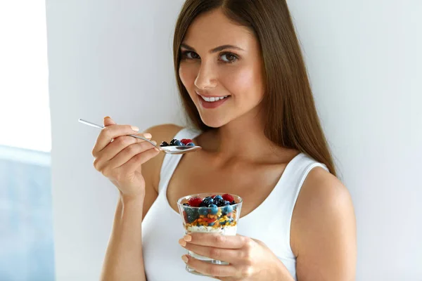 Kobieta jedzenie jogurt, owoce i płatki owsiane na zdrowe śniadanie — Zdjęcie stockowe