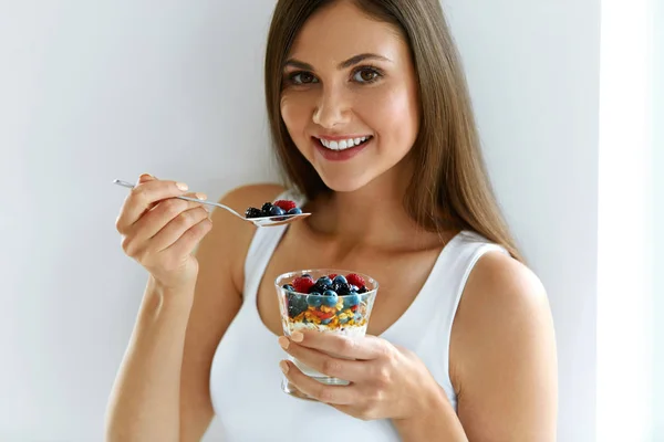 Donna che mangia yogurt, bacche e farina d'avena per una colazione sana — Foto Stock