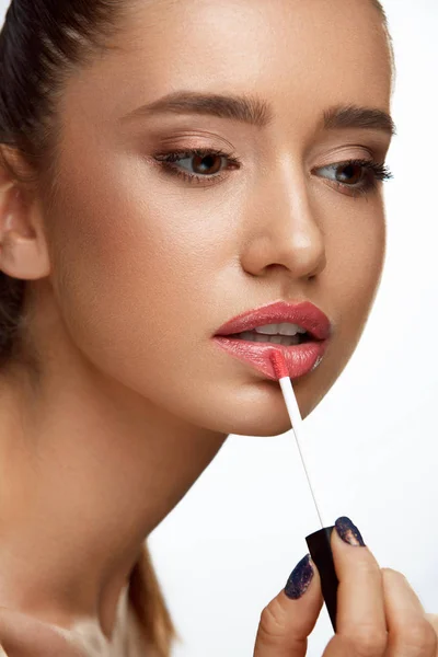 Modelo femenino de moda con cara de belleza aplicando bálsamo labial en los labios — Foto de Stock