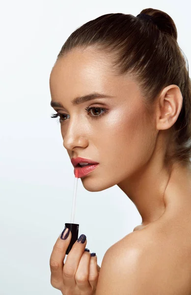 Hermosa mujer haciendo maquillaje usando brillo de labios en los labios. Cosméticos —  Fotos de Stock