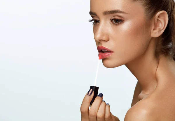 美しい女性の化粧の唇にリップグロスの使用を行います。化粧品 — ストック写真