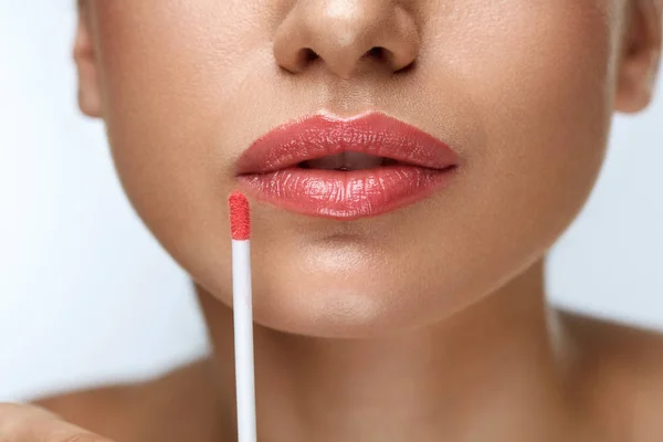 Maquillaje de belleza. Hermosa mujer aplica brillo labial — Foto de Stock