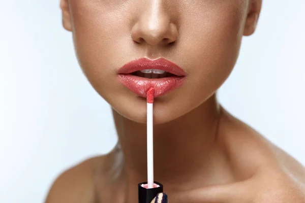 Maquillaje de belleza. Hermosa mujer aplica brillo labial — Foto de Stock